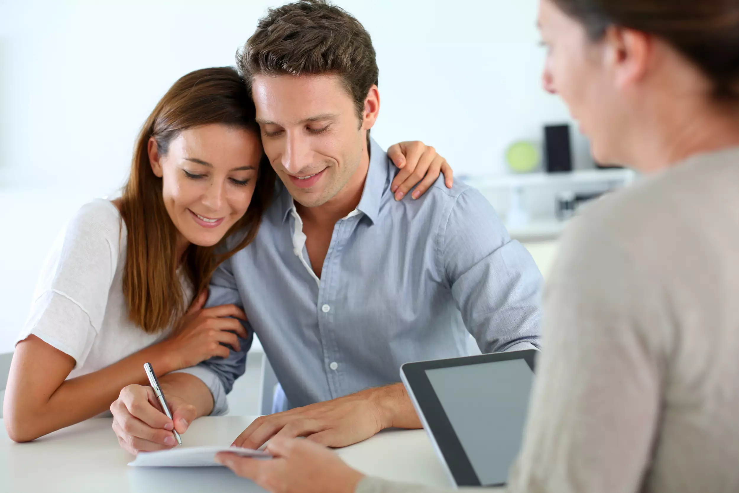 Young couple signing title documents